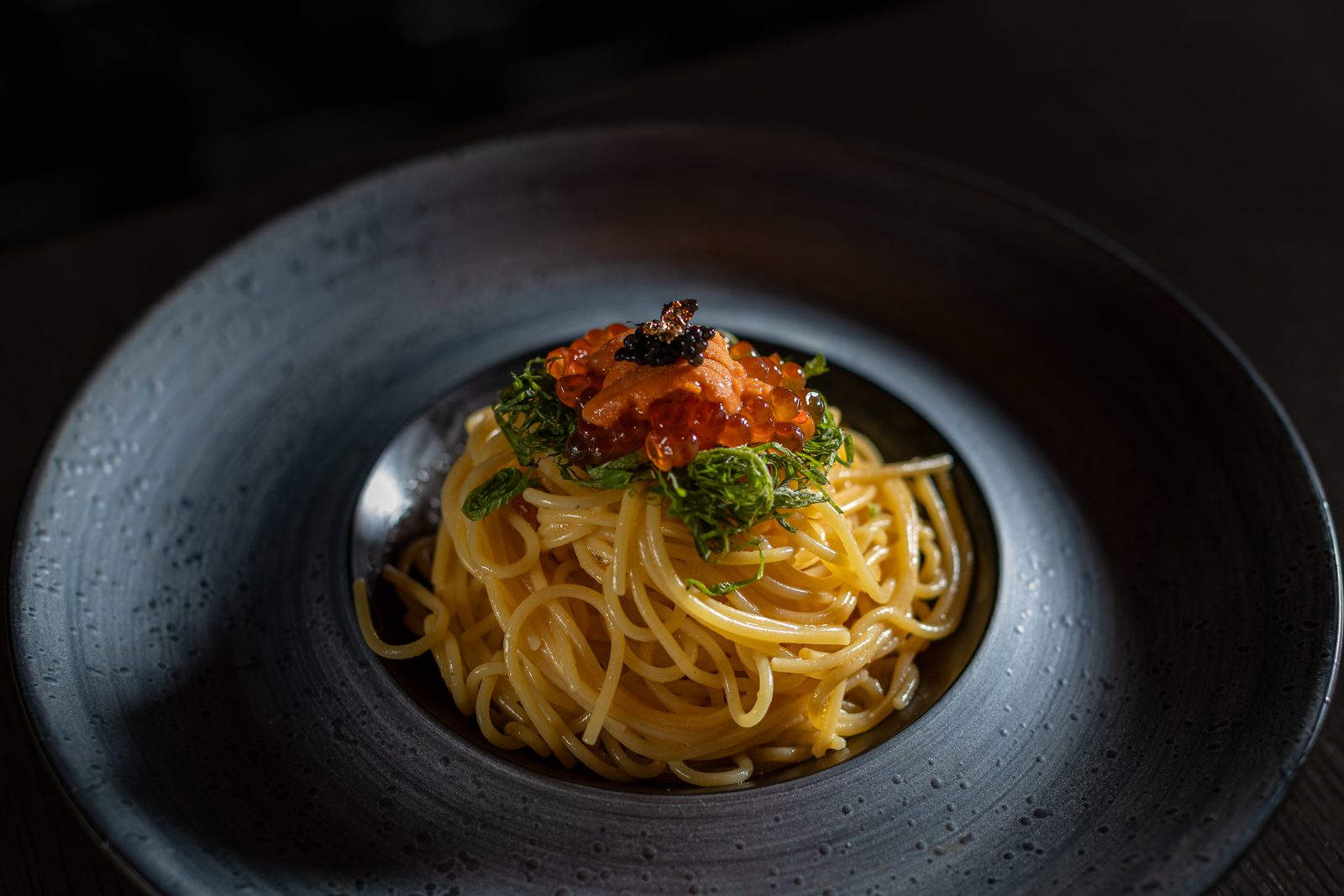 Spaghetti topped with uni and caviar on a black stoneware plate at Ro in Hyde Park
