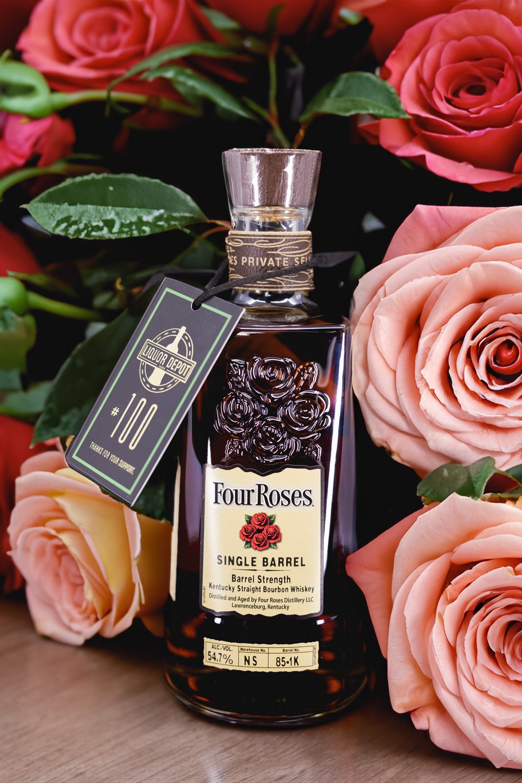 Bottle of Four Roses Single Barrel bourbon surrounded by pink roses